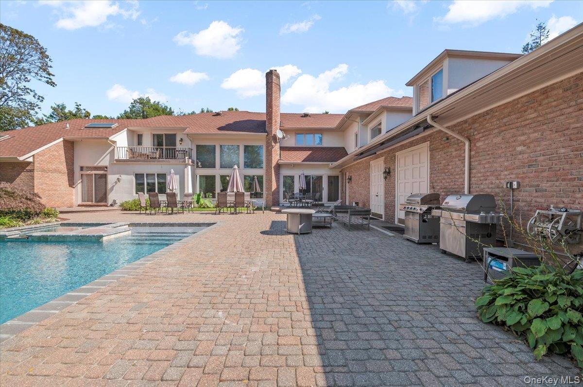 12 Ridge Court Glen Head, NY 11545 - Photo 42 of 46 View of swimming pool with a balcony, a patio area, outdoor dining area, area for grilling, and a pool with connected hot tub