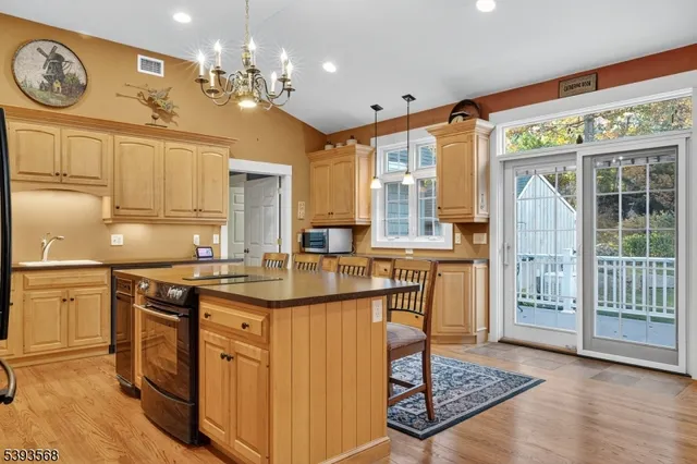 a kitchen with kitchen island granite countertop a sink cabinets and stainless steel appliances