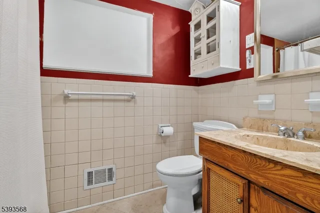 a bathroom with a granite countertop toilet sink and mirror