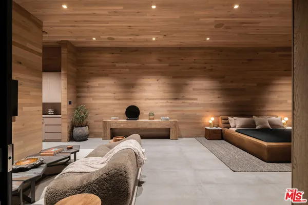 a view of swimming pool with lounge chair and trees in the background