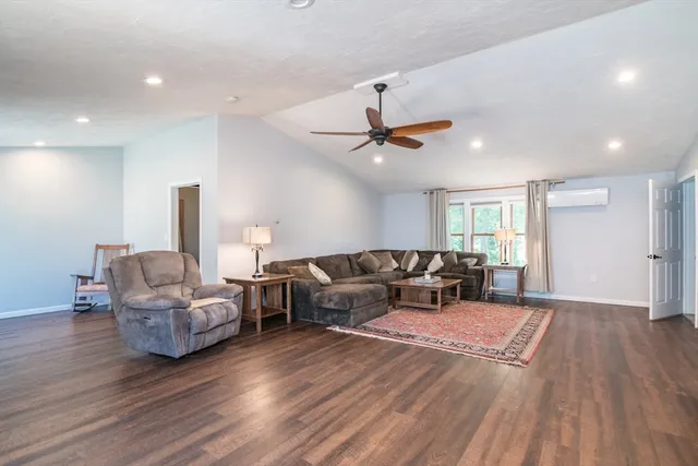a living room with furniture and a wooden floor