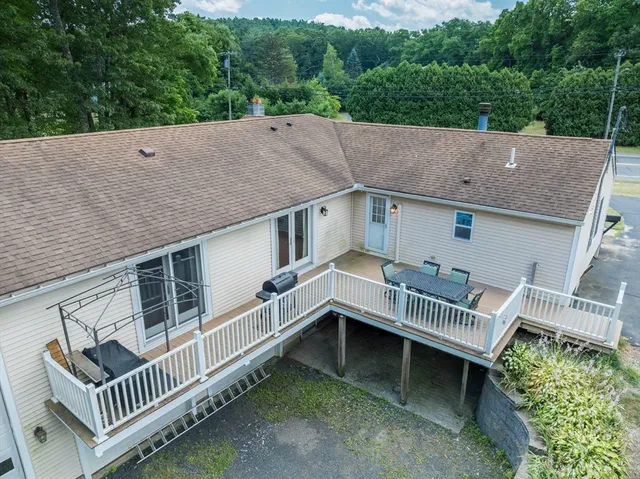 aerial view of a house with a deck and a yard