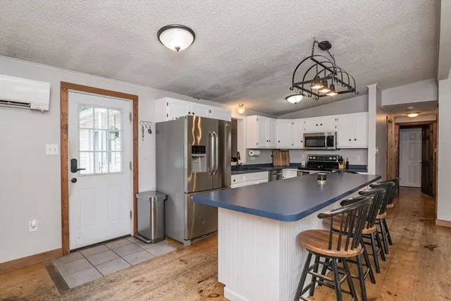 a kitchen with stainless steel appliances a table chairs and chandelier