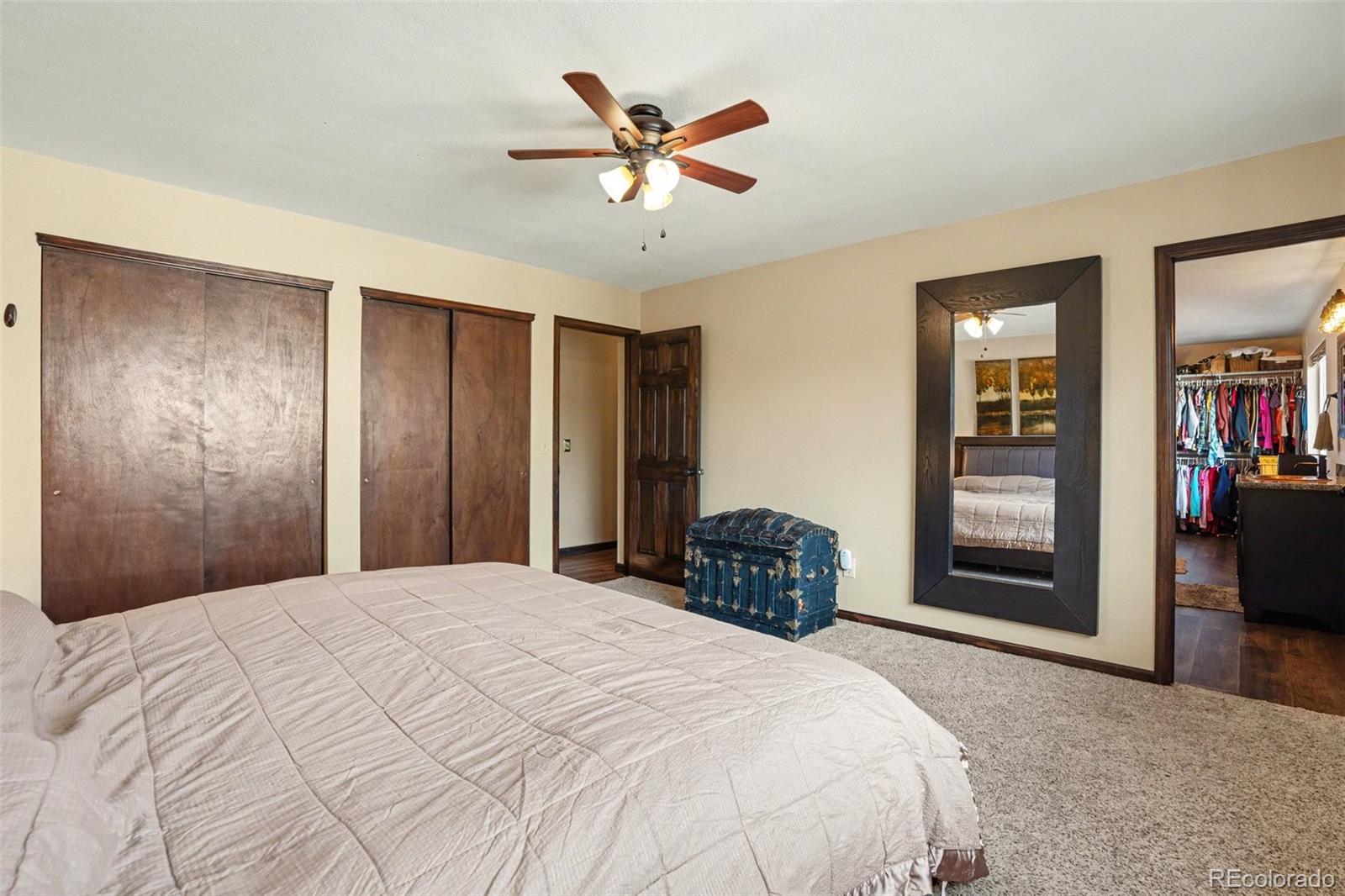 6224 Powell Road Parker, CO 80134 - Photo 12 of 40 a bedroom with a large bed and a ceiling fan