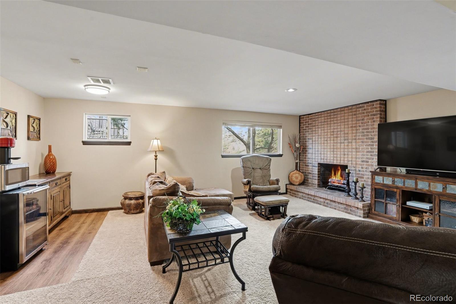 6224 Powell Road Parker, CO 80134 - Photo 10 of 40 a living room with furniture a flat screen tv and a fireplace