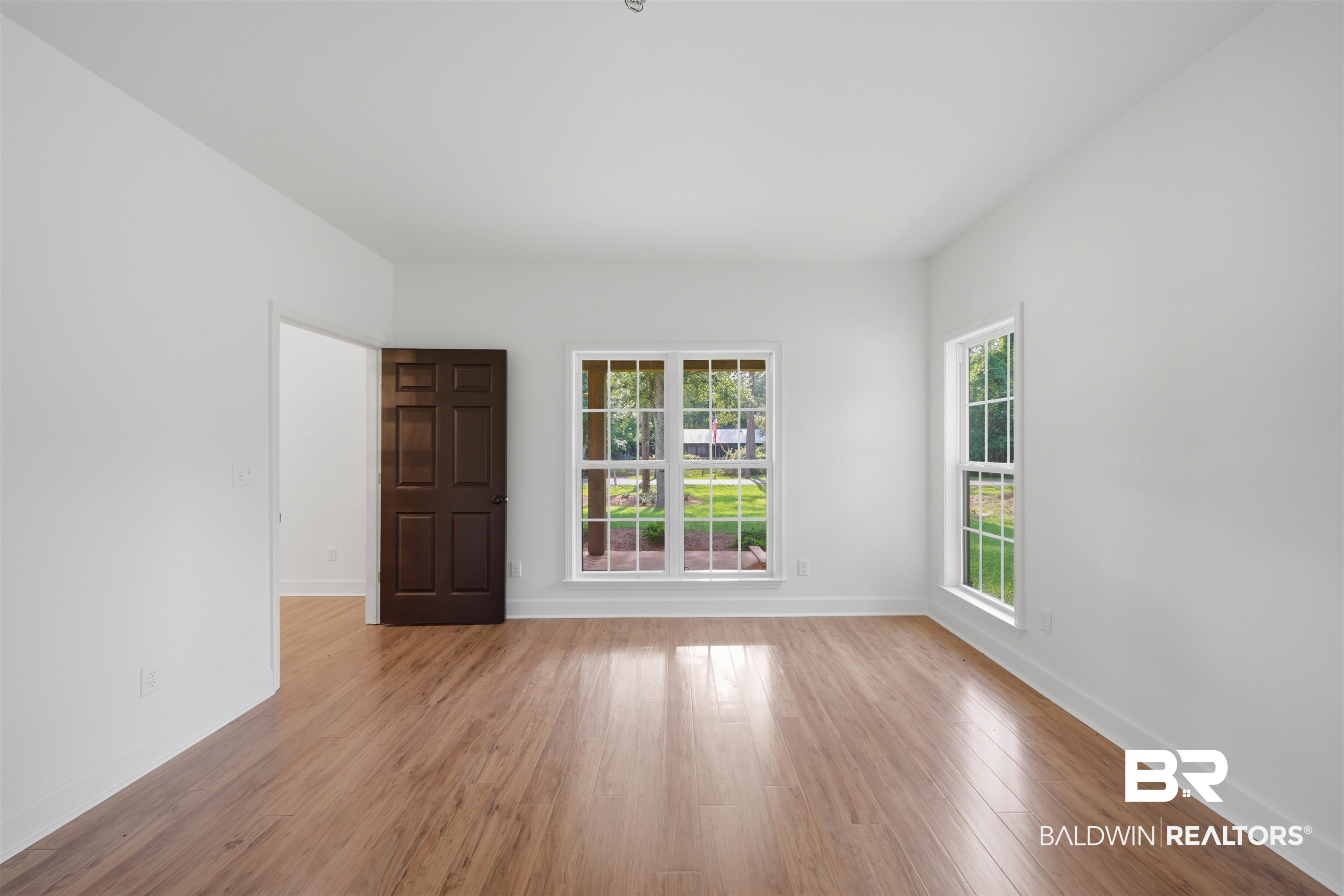 14128 Jackson Lane Foley, AL 36535 - Photo 20 of 36 Bright interior space featuring wood-finish flooring, white walls, and multiple windows with white trim
