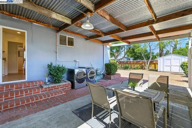 a patio with glass top table and chairs