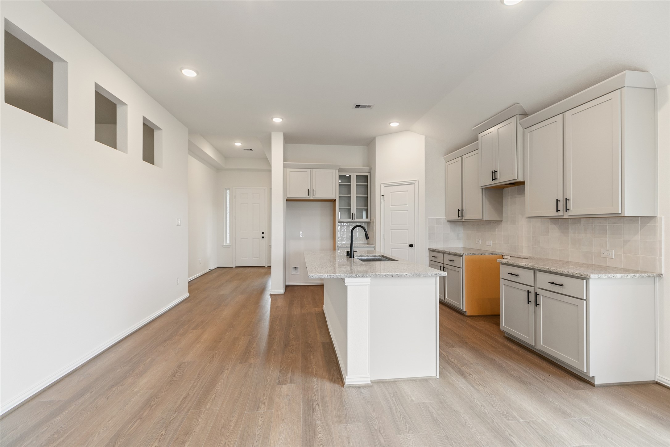 2801 Ruby Laurel Drive Iowa Colony, TX 77583 - Photo 11 of 31 a large kitchen with stainless steel appliances granite countertop a stove a sink a refrigerator and white cabinets with wooden floor