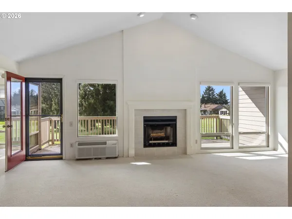 a living room with a fireplace and a floor to ceiling window