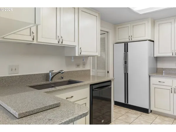 a kitchen with kitchen island white cabinets and refrigerator