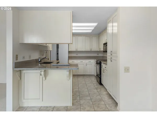 a kitchen with stainless steel appliances granite countertop a sink stove and cabinets