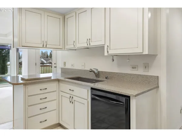 a kitchen with granite countertop white cabinets and a sink