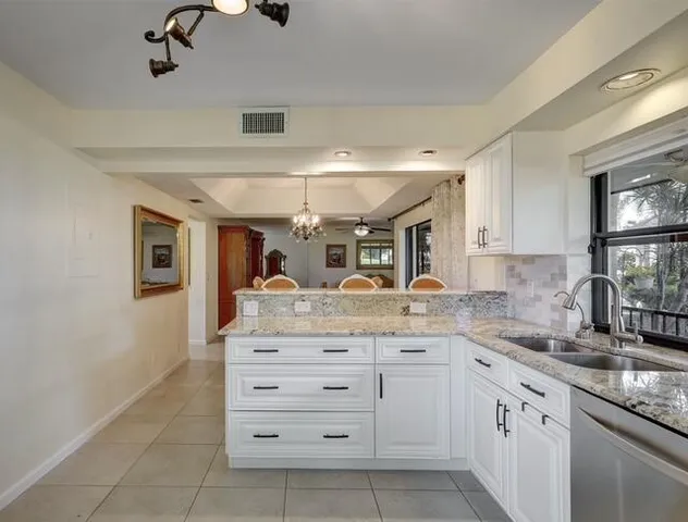 a kitchen with a sink dishwasher a stove and cabinets