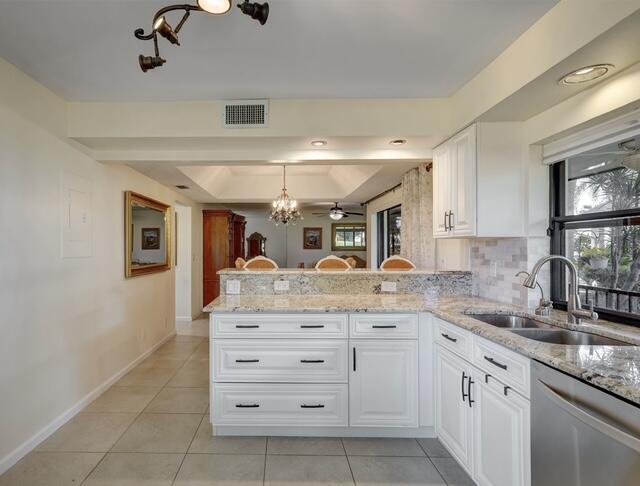 16914 Waterbend Drive, Unit 167 Jupiter, FL 33477 - Photo 14 of 46 a kitchen with a sink dishwasher a stove and cabinets