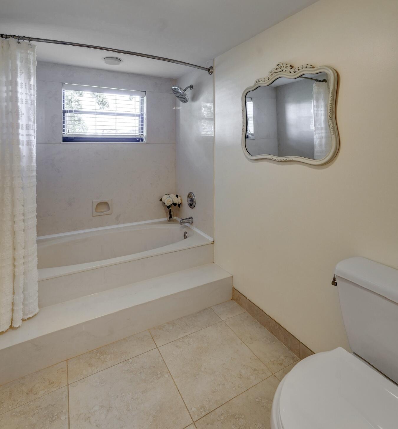 16914 Waterbend Drive, Unit 167 Jupiter, FL 33477 - Photo 21 of 46 a bathroom with a toilet a sink and mirror