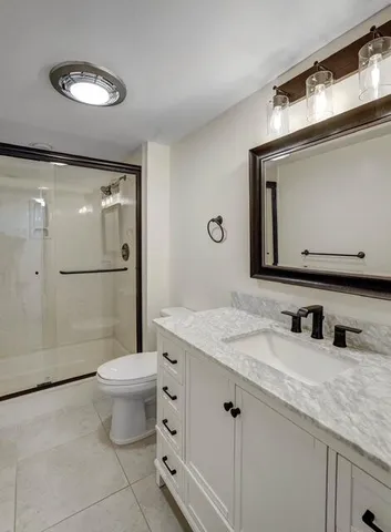 a bathroom with a granite countertop sink toilet and shower