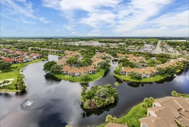 an aerial view of a house with a garden and lake view