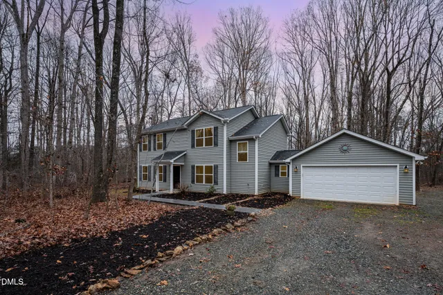 a front view of a house with a garden and yard