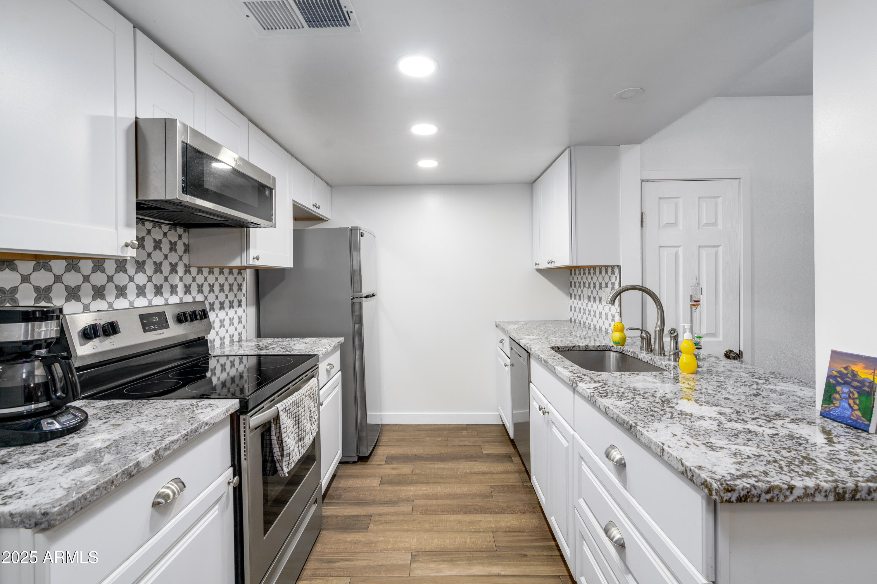 1032 East Redfield Road Tempe, AZ 85283 - Photo 6 of 15 a kitchen with stainless steel appliances granite countertop a sink stove and refrigerator