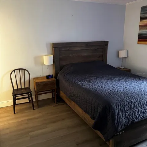 a bedroom with a bed chair and lamp