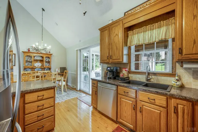 a view of a dining room and livingroom with furniture wooden floor a chandelier