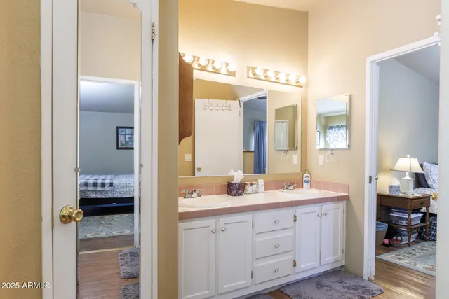 a en suite bathroom with a double vanity sink and a mirror