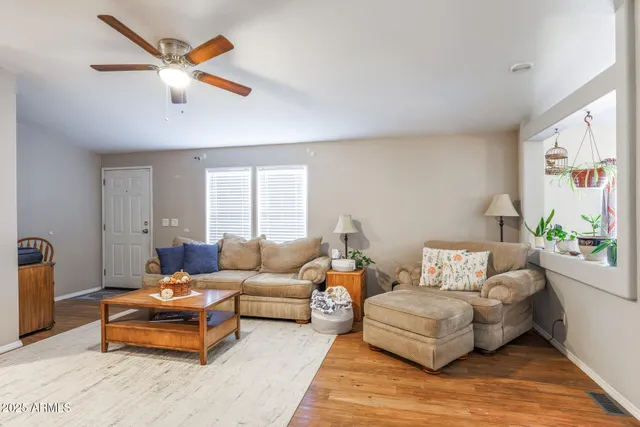 a kitchen with stainless steel appliances kitchen island granite countertop a sink dishwasher and white cabinets with wooden floor