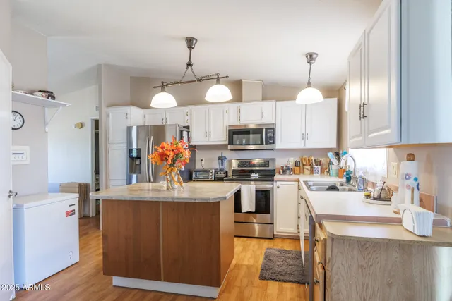 a kitchen with stainless steel appliances granite countertop a sink dishwasher and cabinets with wooden floor