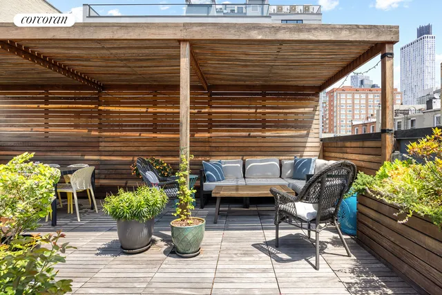 a roof deck with outdoor seating and plants