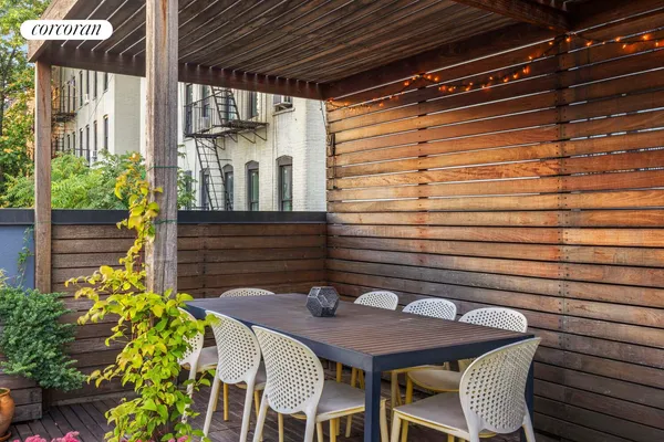a roof deck with outdoor seating and plants