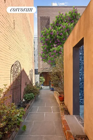 a pathway of a house with a bench