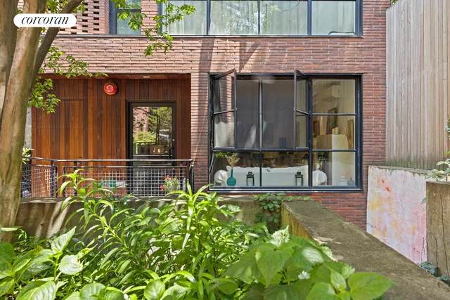 a front view of a house with a tree