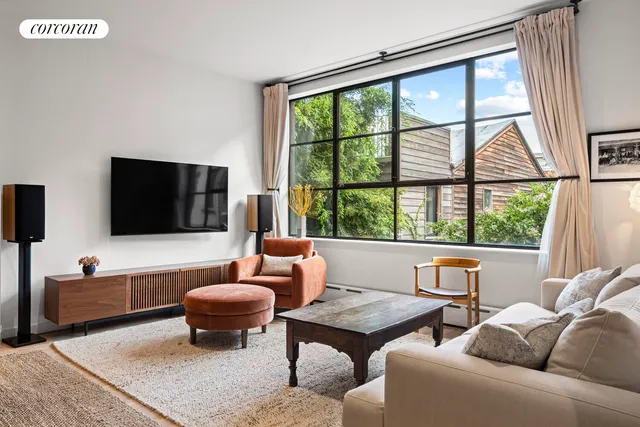 a living room with furniture potted plant a fireplace and a large window