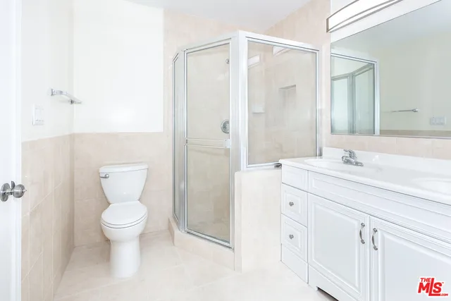 a bathroom with a toilet a sink a vanity and mirror