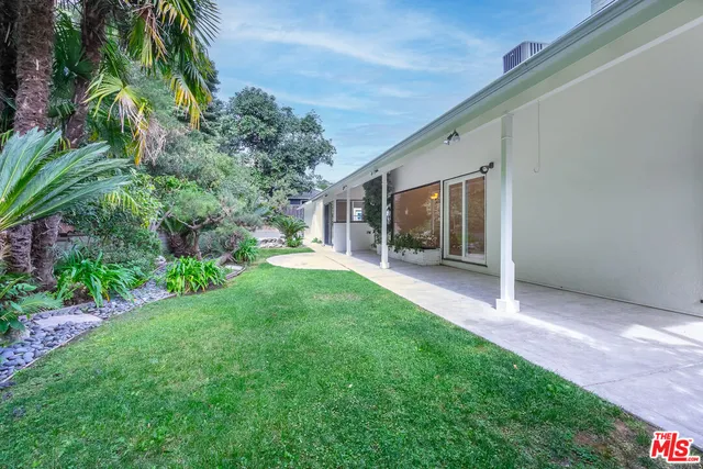 a view of an house with backyard and porch