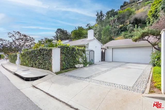 a view of a house with a yard and potted plants