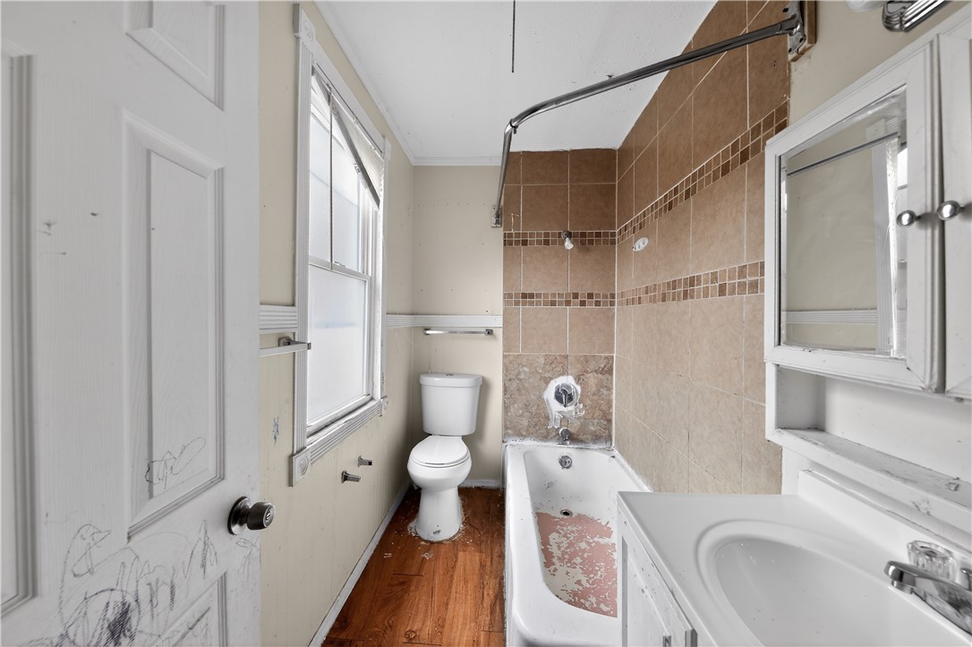 205 Rita Street Dayton, OH 45404 - Photo 19 of 34 This bathroom features a shower, bathtub, toilet, and vanity, all with a simple design.
