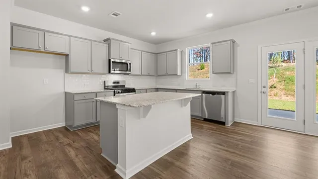 a kitchen with a sink cabinets and wooden floor
