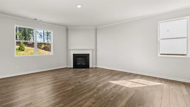 an empty room with windows and fireplace