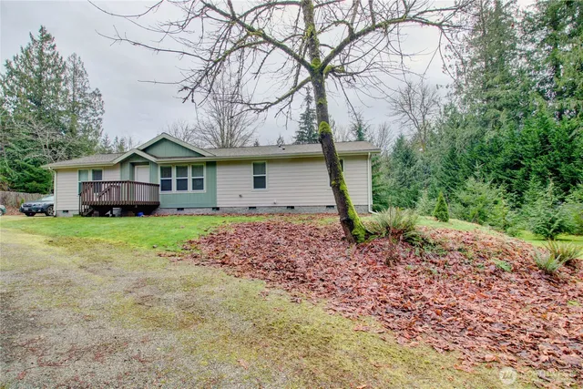 an aerial view of residential house with outdoor space and trees all around