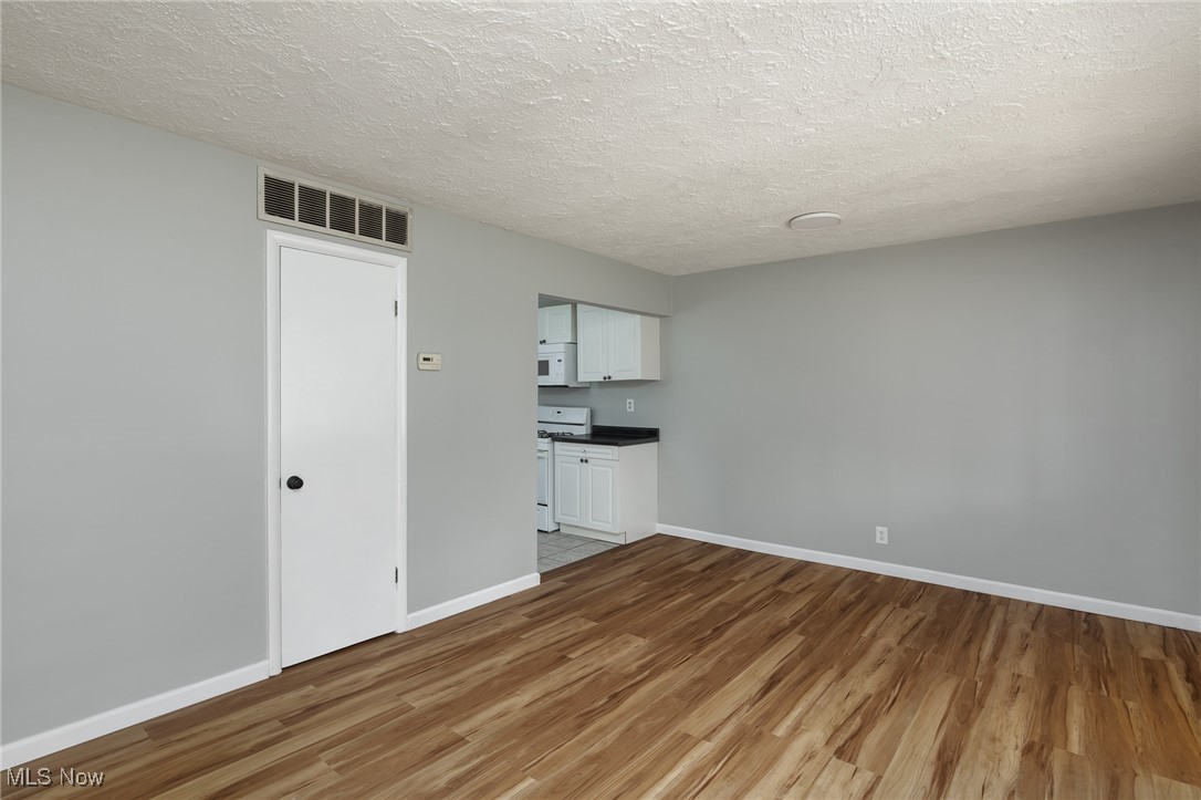 4782 Belle Meadow Road Mentor, OH 44060 - Photo 7 of 22 Spare room featuring a textured ceiling and hardwood / wood-style floors