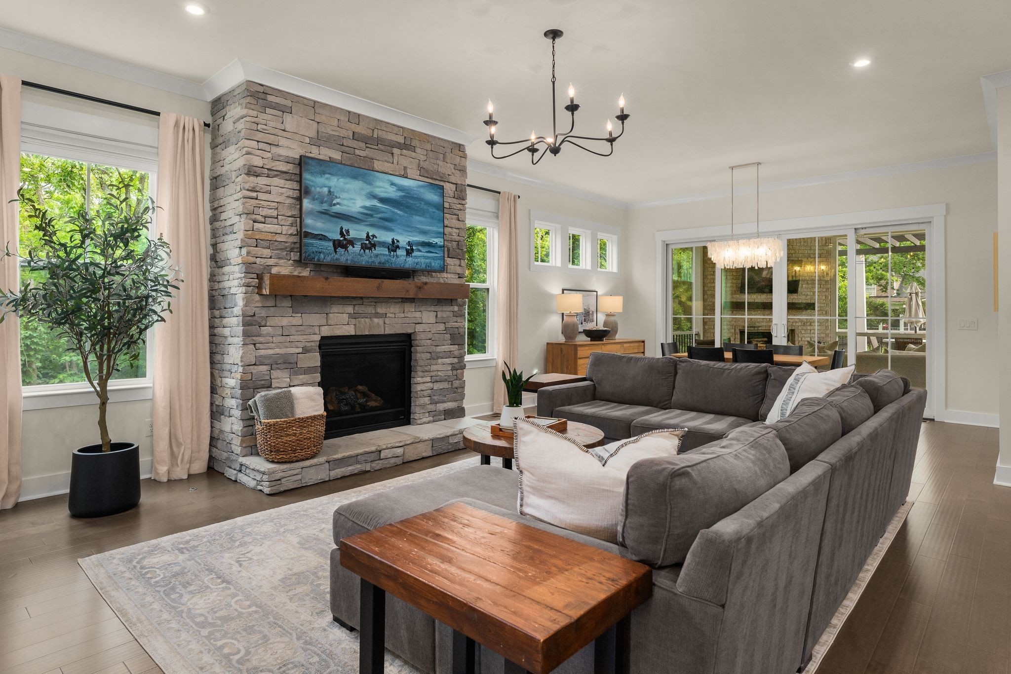 454 Cardel Lane Franklin, TN 37064 - Photo 12 of 53 a living room with furniture a chandelier a fireplace and a potted plant