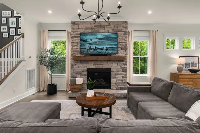 a living room with furniture a fireplace and a chandelier
