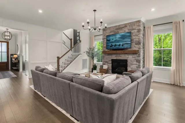 a living room with furniture a fireplace and a chandelier