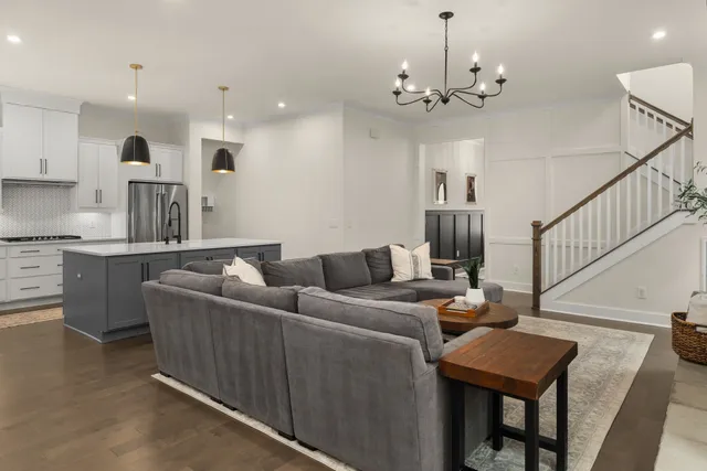 a living room with furniture a dining table and a chandelier
