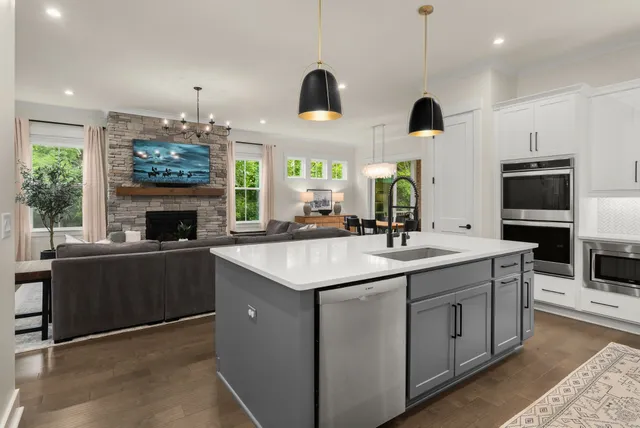 a kitchen with kitchen island granite countertop a sink a counter top space appliances and cabinets