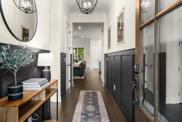 a hallway with dining area and chandelier