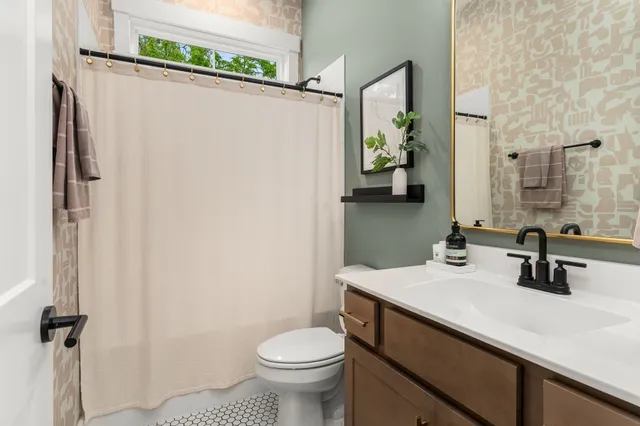 a bathroom with a sink a toilet and shower