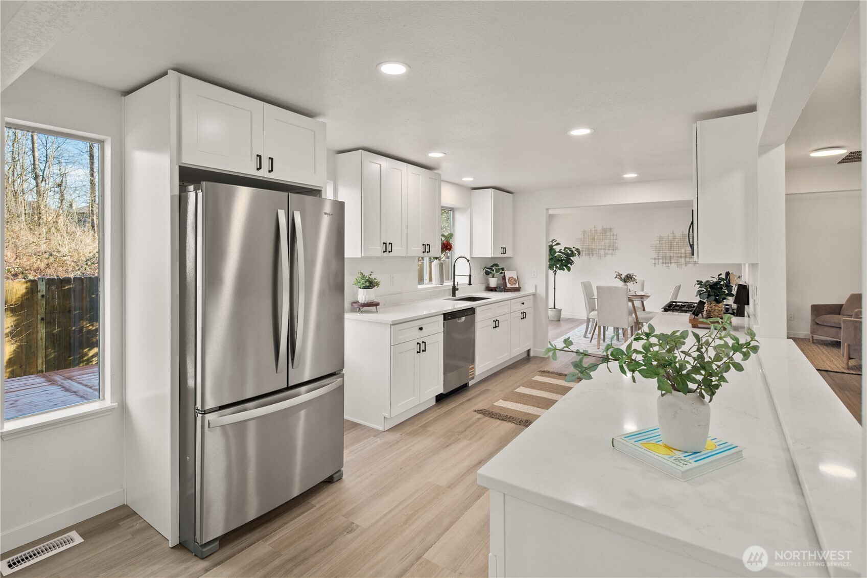 18307 130th Avenue Southeast Renton, WA 98058 - Photo 12 of 36 a kitchen with stainless steel appliances a refrigerator a sink a stove and white cabinets