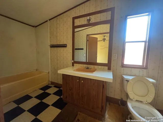 a bathroom with a sink a toilet and mirror